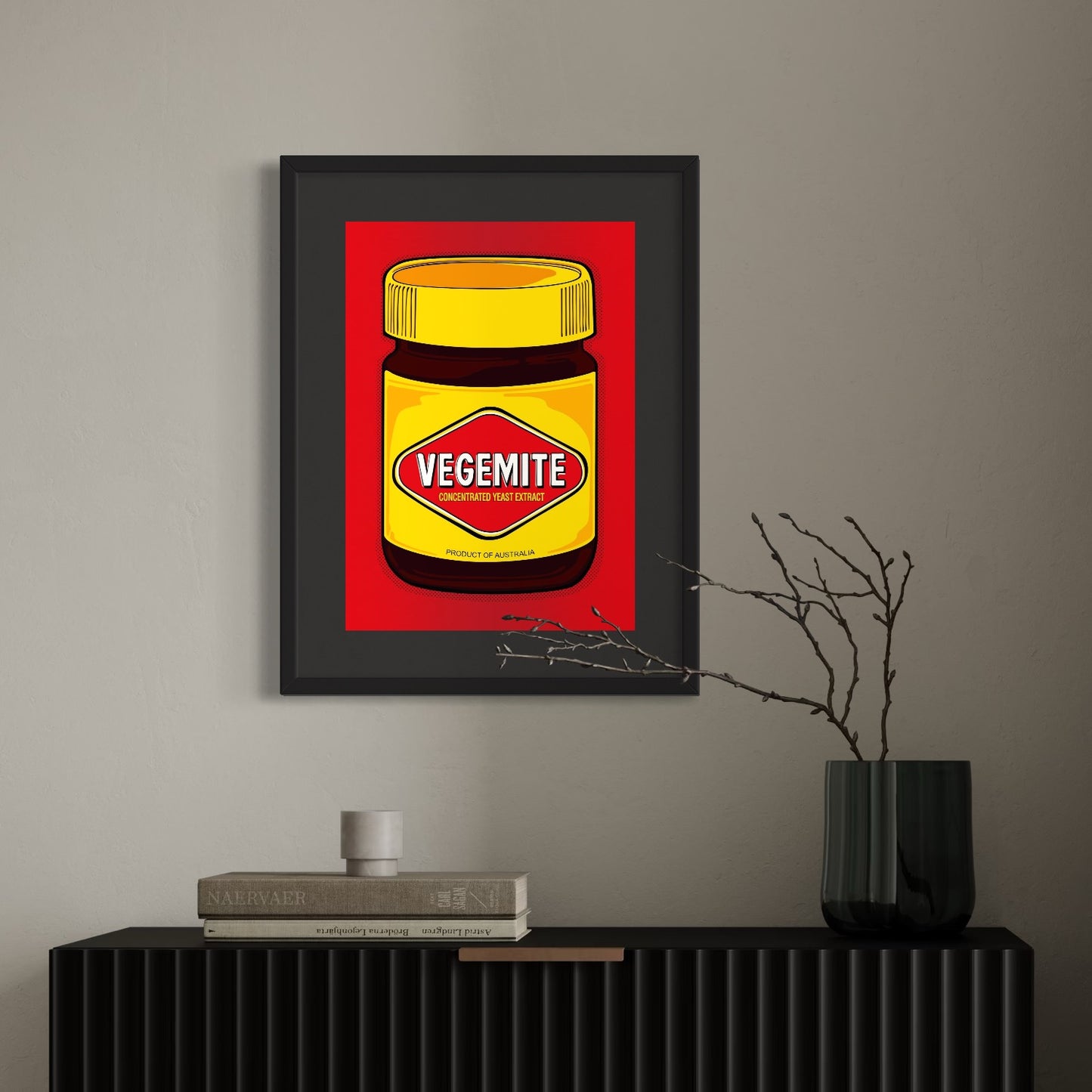 Vegemite in full pop—yellow lid, red diamond, and Aussie pride dialed to eleven. A3 giclée from Nessy Pop Art, framed above a minimalist console with stacked books, bare branches, and a green vase. A national icon styled for the modern home.