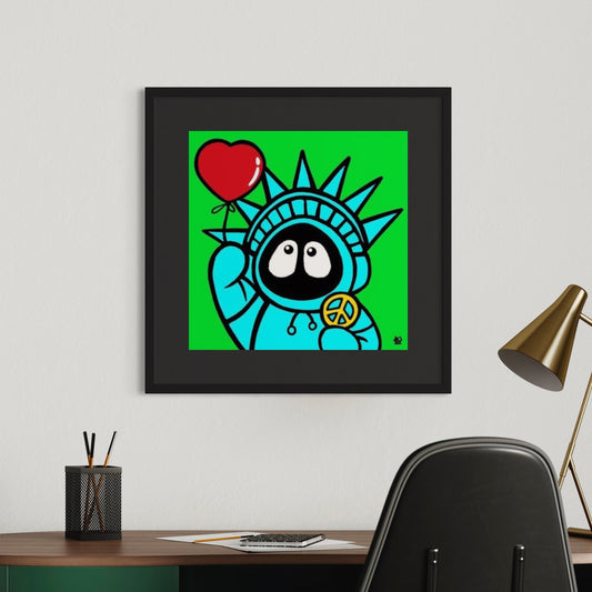 Framed colorful artwork of Hoodie Boy resembling the Statue of Liberty holding a heart and peace symbol, displayed on a wall above a desk.