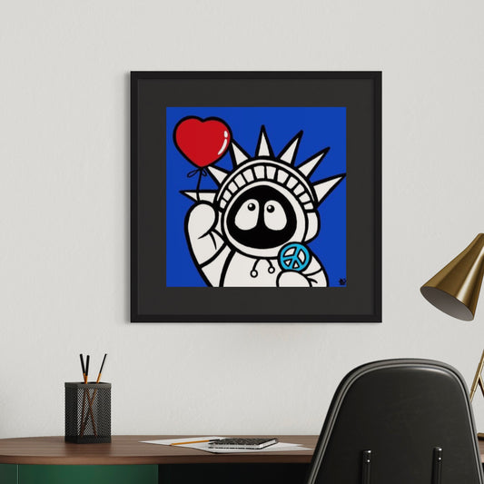 Framed artwork of Hoodie Boy resembling the Statue of Liberty with a heart and peace symbol on a blue background, hanging above a desk.