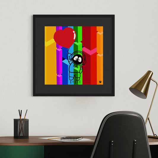 Framed colorful artwork of Hoodie Boy being lifted by a heart balloon with a rainbow geometric background, on a wall above a desk with office supplies.
