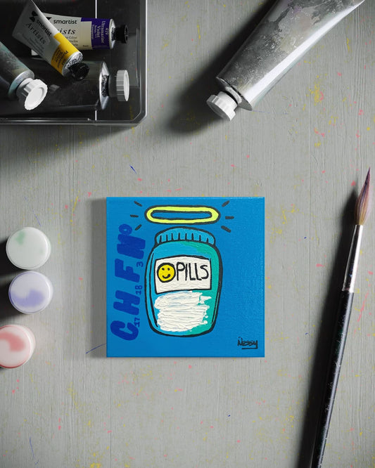 Small painting of a blue pill bottle with a smiley face on a gray surface with art supplies.