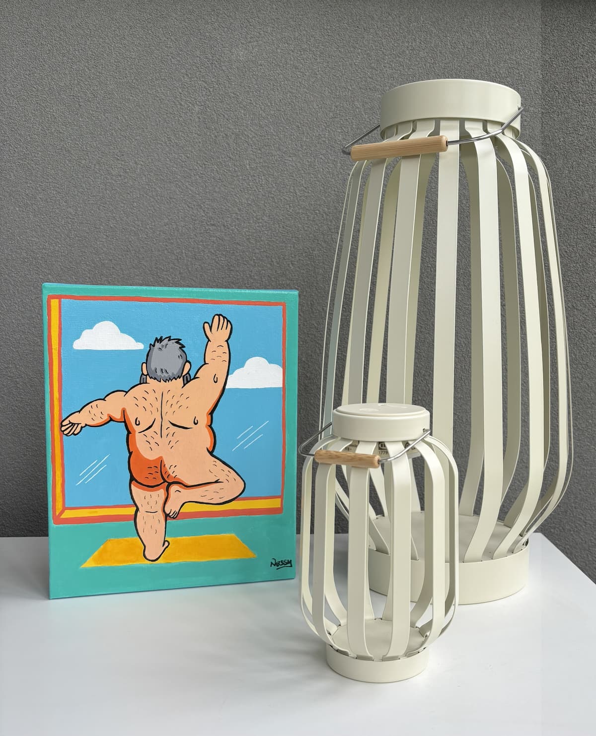 Cartoon canvas of silver-haired figure mid-jump into pool, paired with cream slatted lanterns—staged against white wall for playful summer vibe. Acrylic canvas, 8x10in from Nessy Pop Art.