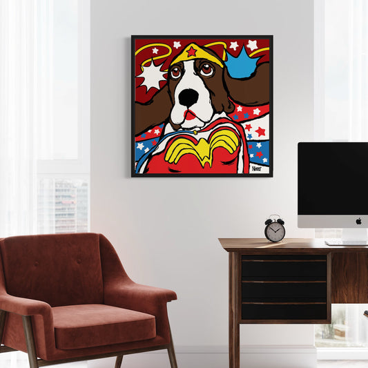Framed artwork of a Basset Hound dressed as Wonder Woman with stars and stripes background on a wall above a desk.