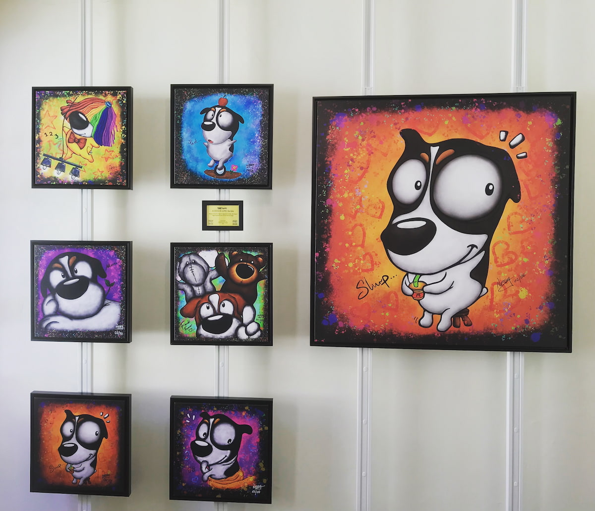 Collection of cartoon dog paintings on a gallery wall