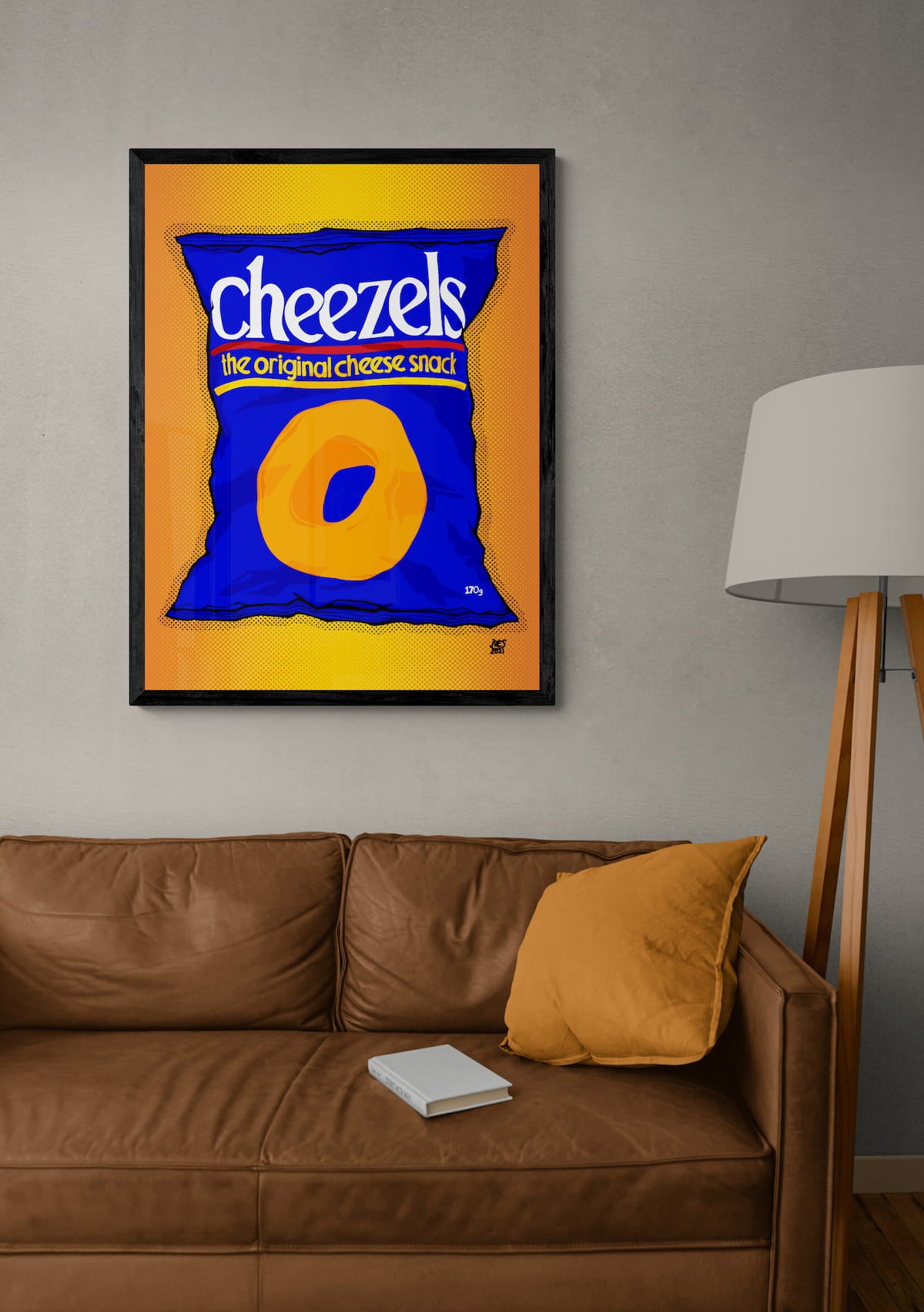 Framed artwork of a Cheezels bag on a wall above a brown couch.