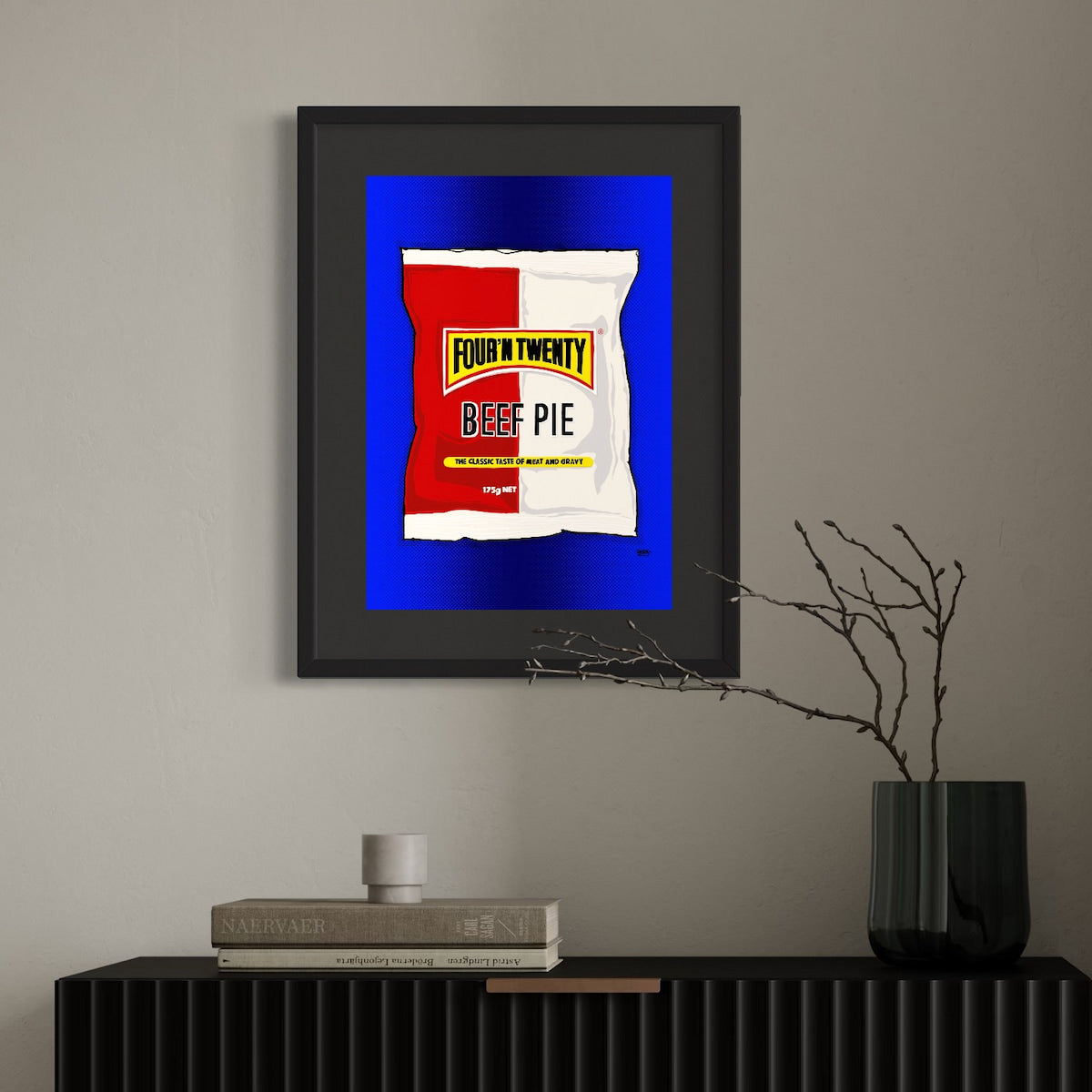 Framed artwork of Four'N Twenty food packaging design on a wall above a black shelf.