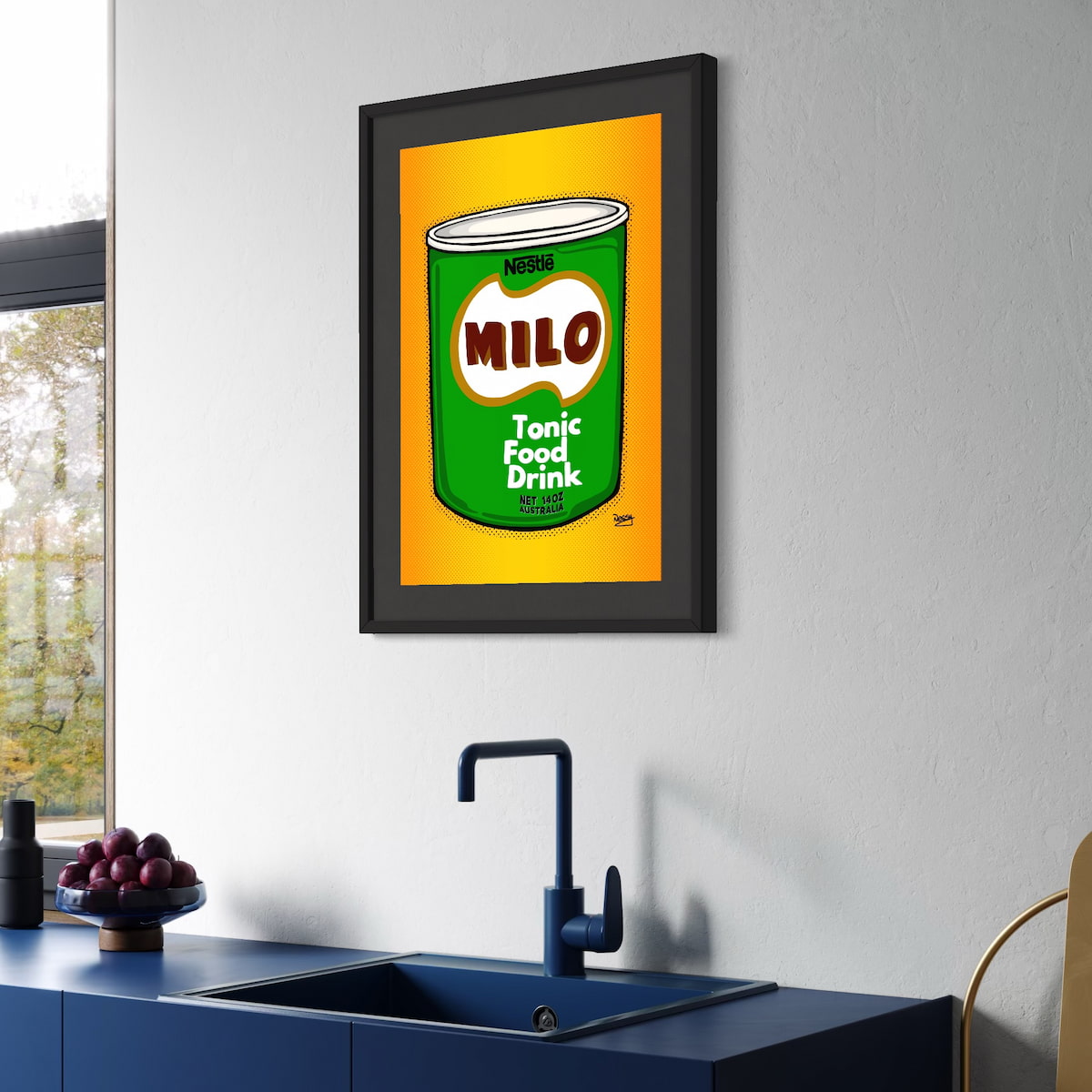 Framed artwork of a vintage Milo can on a wall above a kitchen sink.