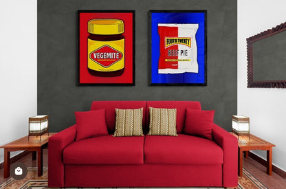 Red sofa with decorative pillows in a room with framed artwork on the wall.