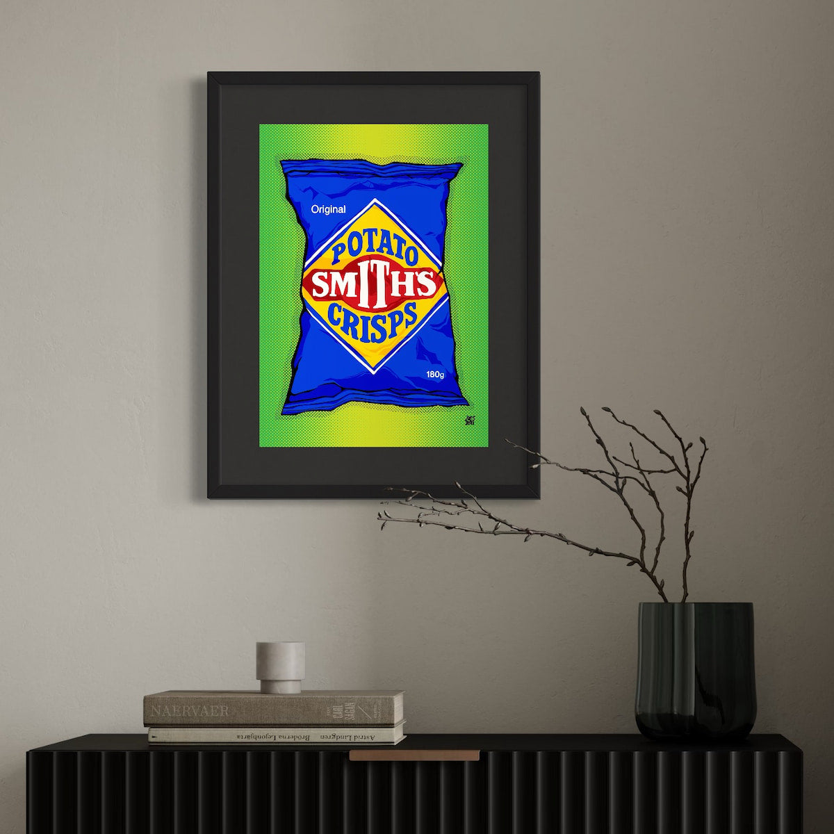 Framed artwork of a Smith's Crisps packet on a wall above a black console table.