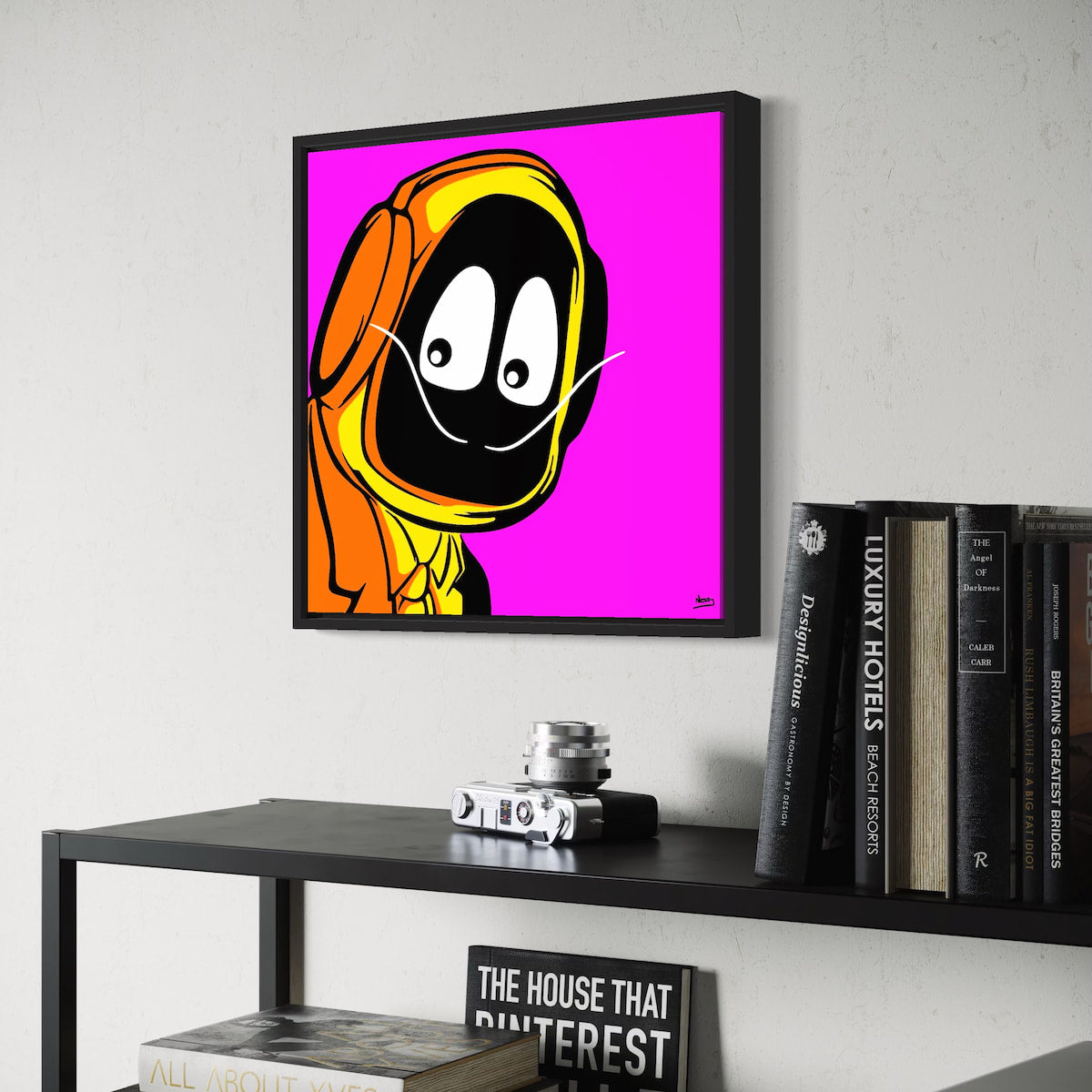 Framed colorful artwork of Hoodie Boy dressed as Salvadore Dali on a wall above a shelf with books and decor.