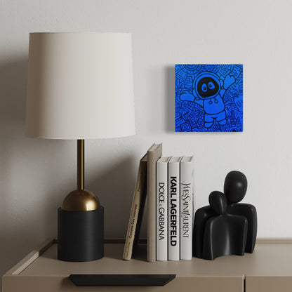 Decorative shelf with a lamp, books, and a black sculpture against a white wall with artwork of Hoodie Boy reaching for a hug with a black and blue geometric background.