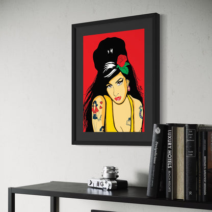 Framed artwork of Amy Winehouse on a wall above a shelf with books and a camera.