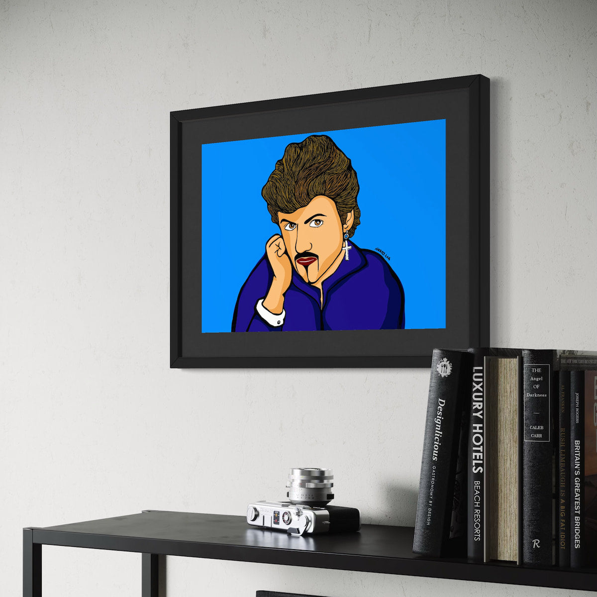 George Michael in purple, hand to cheek, gaze half turned—quiet drama in a sea of blue. Framed above a shelf of travel books and vintage camera, this A3 giclée from Nessy Pop Art brings soulful pop icon energy to modern interiors.