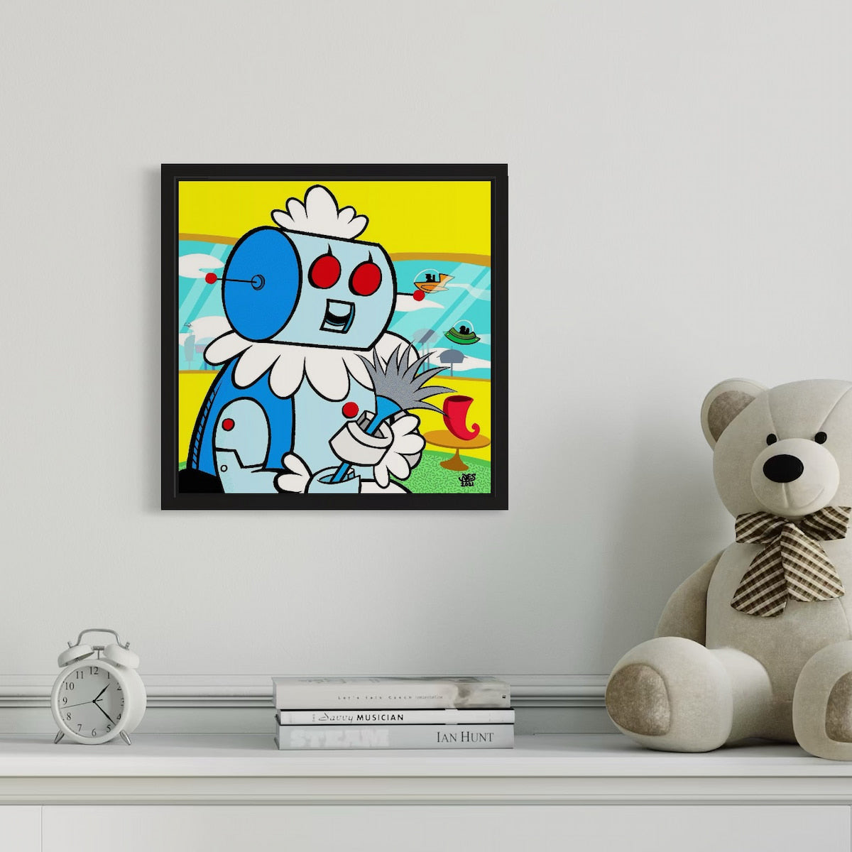 Framed cartoon artwork on a shelf with a teddy bear and alarm clock.
