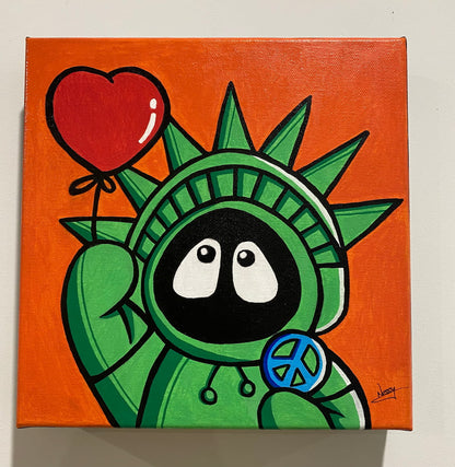 Painting of Hoodie Boy as the Statue of Liberty with a heart balloon and peace symbol, with an orange background, on a white wall.
