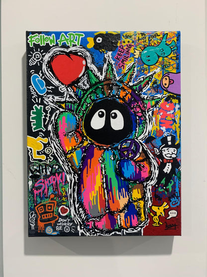 Colorful painting depicting Hoodie Boy as the Statue of Liberty with a heart balloon and peace symbol surrounded by iconic images, on a white wall.