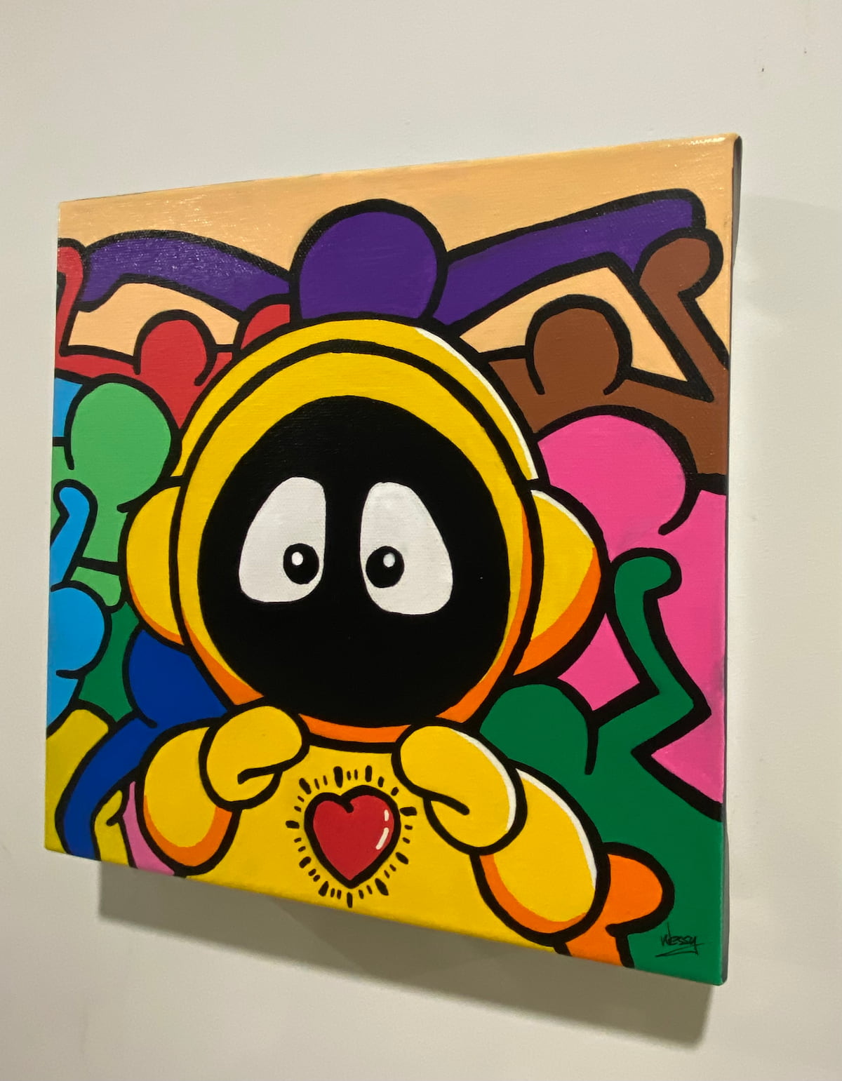 Colorful painting of Hoodie Boy in yellow with a heart on his chest and Keith Haring characters surrounding him.