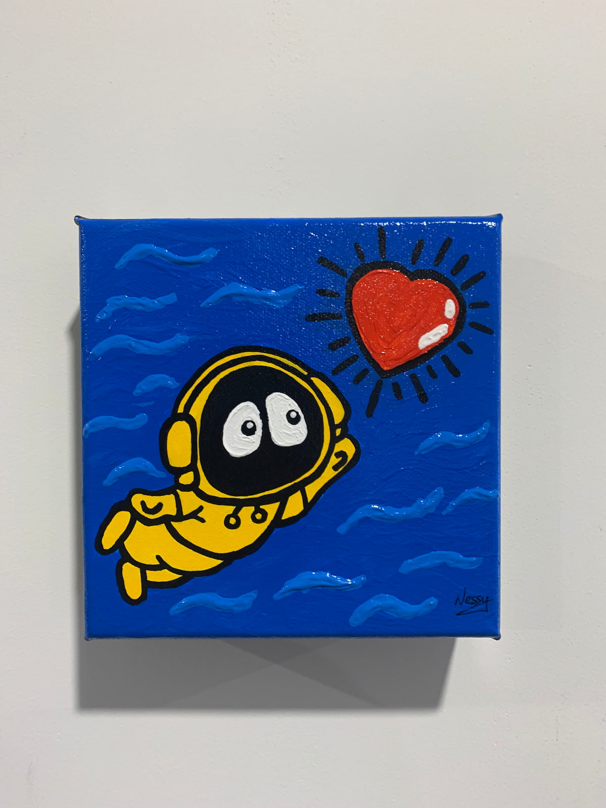 A colorful painting of Hoodie Boy swimming towards a shinning heart, on a white wall.
