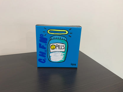 Blue painting with a design of a pill bottle labeled 'Pills' on a dark surface.