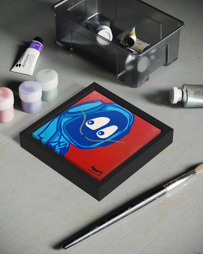 Small painting of Hoodie Boy dressed as Salvadore Dali on a gray surface with art supplies