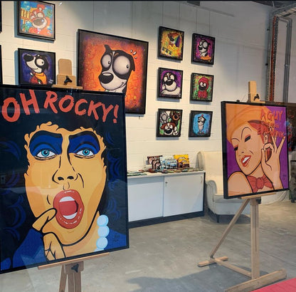 Art gallery with colorful paintings on easels and walls