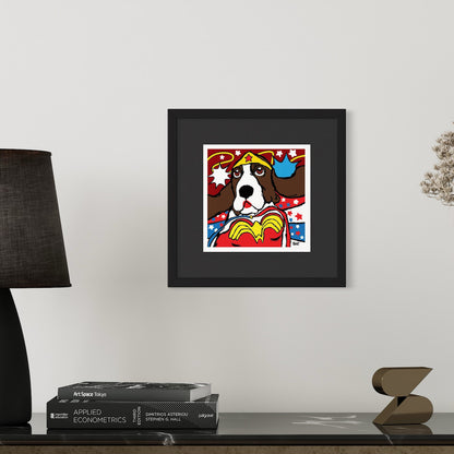 Framed artwork of a Basset Hound dressed as Wonder Woman on a white wall.